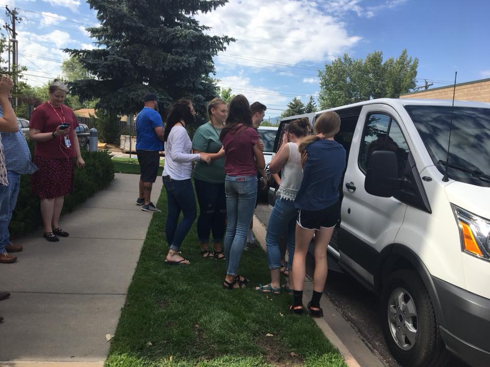 students climbing into van