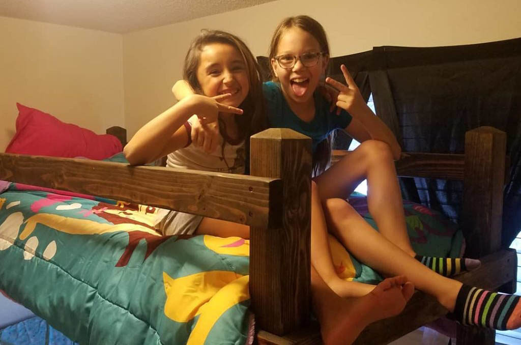two girls sitting on a bunkbed