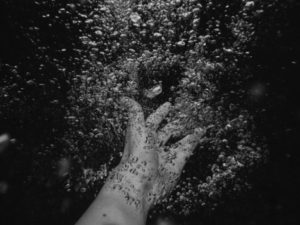 hand reaching in water with bubbles