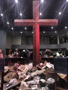 A pile of garbage laying at the foot of the cross.