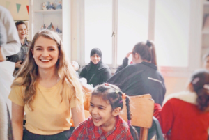 young woman smiling at camera and young Greek girl laughing and looking to the side