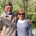 Jim and Mary Williams standing together in front of a pond.